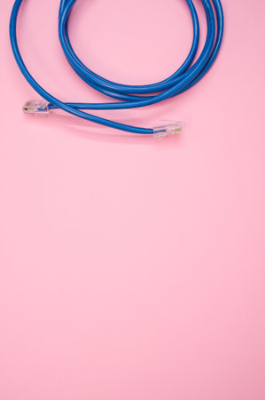 A vertical shot of a blue LAN cable isolated on a pink backgroundの写真素材
