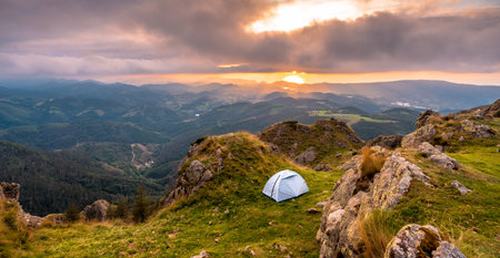 A closeup shot of wild camping on the top of a mountain at sunset