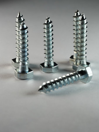 A vertical shot of lag screws on a white surface