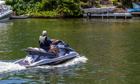 A closeup shot of a tourist driving a jet ski on the water
