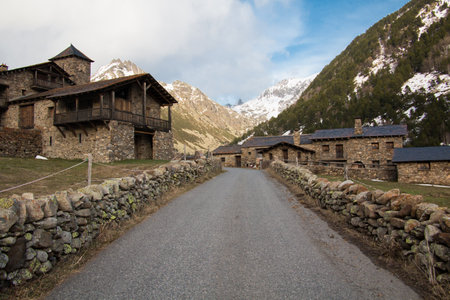 wooden and stone houses in snowy mountain landscape and forestの写真素材