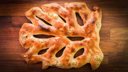 A closeup shot of a freshly baked odd-shaped bread on a wooden surface