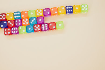 Colorful dice in a row isolated on a beige backgroundの写真素材