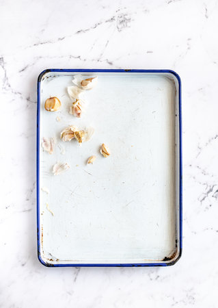 White Enamel Roasting Pan with Garlic and Copy Space