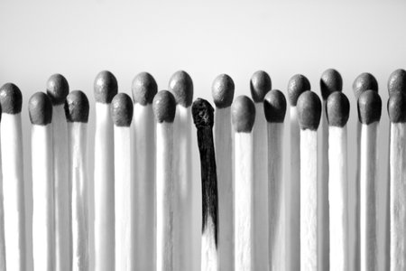 A black-and-white photo of the matches and a burned one in the middleの写真素材