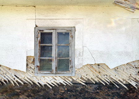 A wall of a traditional Mediterranean white house with an old windowの写真素材
