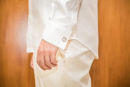 A closeup shot of a man wearing a white shirt and pants
