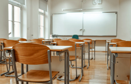 Empty chairs and tables in classroom. No people in school classroom.の写真素材