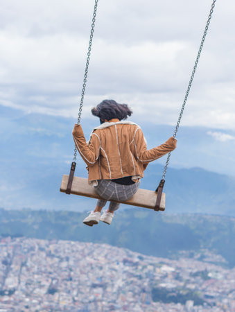 A young cute female steaming in the air on a large swing