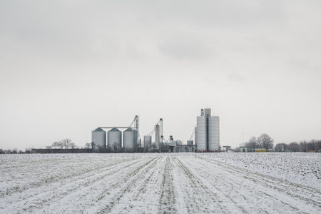 A large snowy field with an industrial plant in the horizonの写真素材