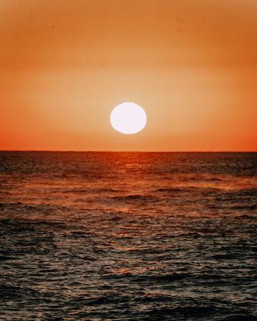 A vertical shot of the sea under the sunlight during a beautiful sunset in the eveningの写真素材