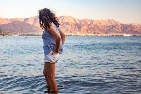 A female with curly hair at the beachの写真素材