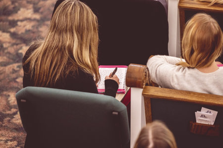 A female making notes during a lecture in a hallの写真素材