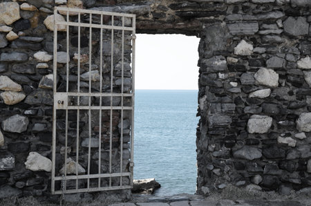 Open Metal Gate Door with View Over Mediterranean Sea in Liguria, Italy.の写真素材