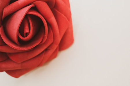 An artificial red rose isolated on light backgroundの写真素材