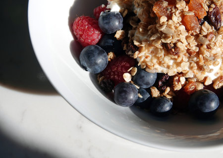 A delicious bowl of muesli with blueberries and raspberries for breakfastの写真素材