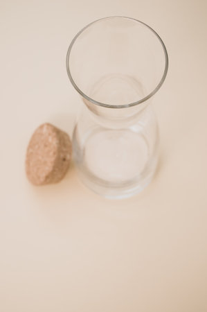 A vertical shot of an empty glass with a cork cover isolated on a pink background with copyscapeの写真素材