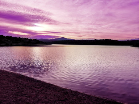 A breathtaking view of a lake and a purple sunsetの写真素材