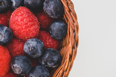 A closeup shot of blueberries raspberries in a basket