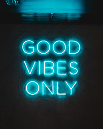 A blue neon glowing light on a wall with words ''Good Vibes Only''の写真素材