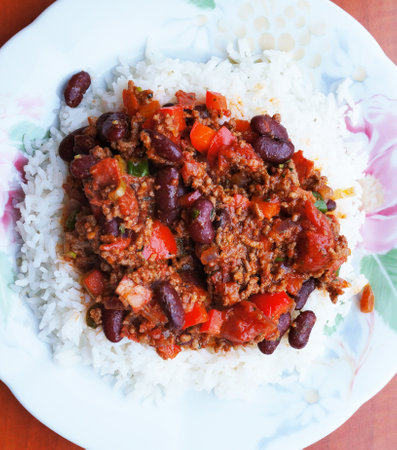 A top view of chili con carne and rice on a white plateの写真素材