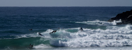 Surfers on the broken head beach surf spot near Byron Bay, Australia