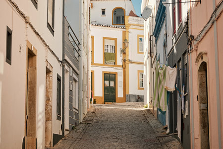 The narrow streets with old buildings and laundry hanging in Algarve, Portugalの写真素材