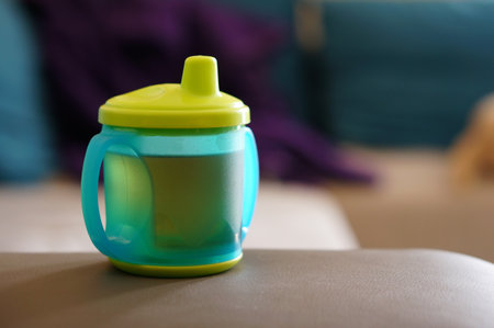 Plastic baby drinking cup on sofaの写真素材