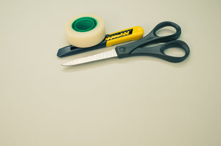 A closeup shot of scissors adhesive tape and a utility knifeの写真素材