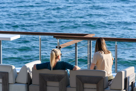 Two blonde women sitting in Terraza  enjoying the beautiful view of the blue sea
