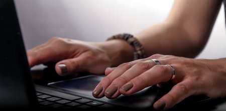 A closeup shot of female hands typing on a laptop keyboardの写真素材
