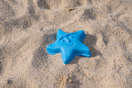 A closeup shot of a toy for playing with sand in a starfish shapeの写真素材