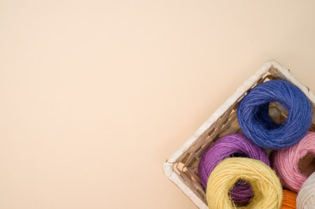 Colorful thread rolls in a box isolated on a beige backgroundの写真素材