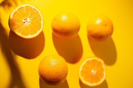A closeup shot of fresh oranges on yellow background