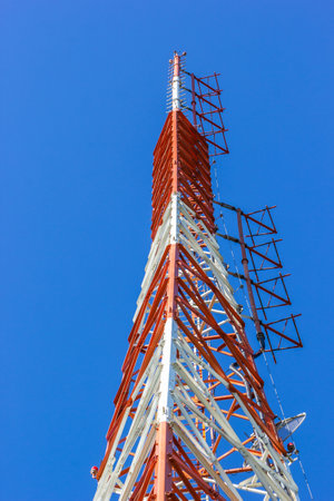 A vertical shot of cell tower on blue sky background