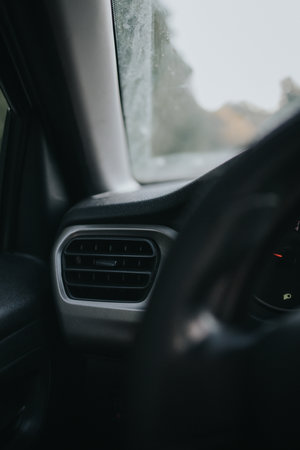 A vertical shot of a car air vent and a front windowの写真素材