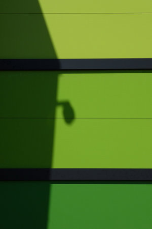 A green wall with a shadow of a lampの写真素材