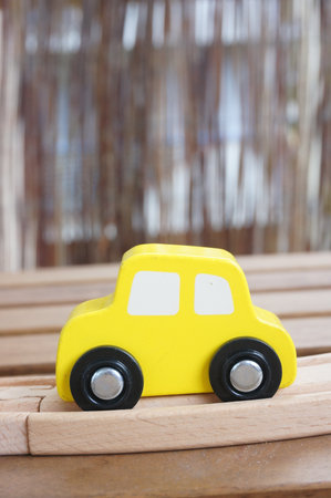 Yellow wooden toy car on a trackの写真素材