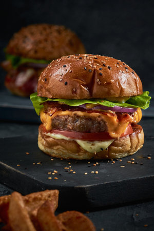 A vertical shot of a delicious burger on a blackboardの写真素材