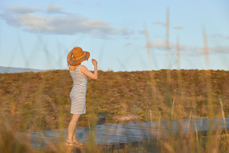 A girl walking along a wooden path to the beachの写真素材