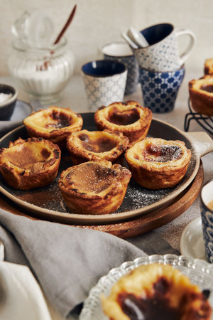 A delicious Pastel de Nata Vanilla pastries with espresso on a white table