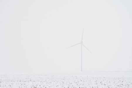 A large wind turbine on a snowy bright fieldの写真素材