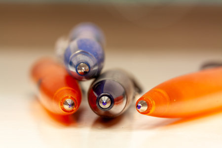 A closeup shot of blue and orange pens on a blurred backgroundの写真素材