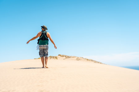 A young father with his newborn son walking along the Monsul beach in Almeria, Spainの写真素材