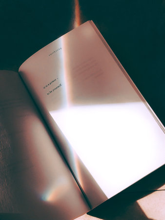 A top view of an open book on the dark background with a ray of colorful light and shadeの写真素材