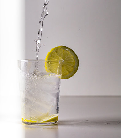 A closeup of a glass of Mauresque cocktail with a lemon slice isolated on white background