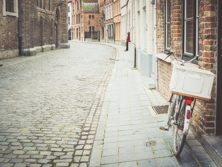 An old street with buildings and bicycle in Bruges, Belgiumの写真素材
