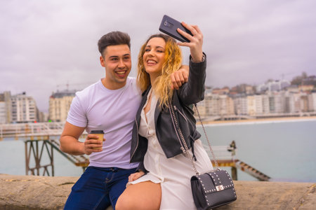 A cute happy couple enjoying vacation, traveling and taking selfies via smartphoneの写真素材