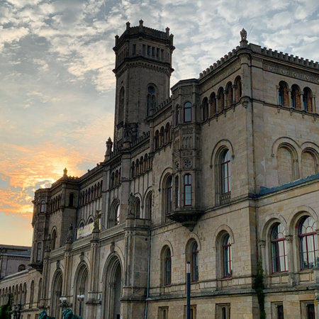 A vertical of the historical Leibniz University Hannover under the cloudy blue sky in Germanyの写真素材