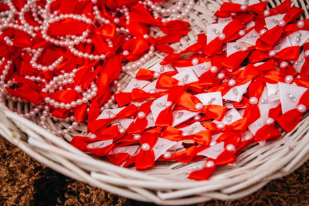 A high angle shot of pearl jewelry with red bows in a basketの写真素材